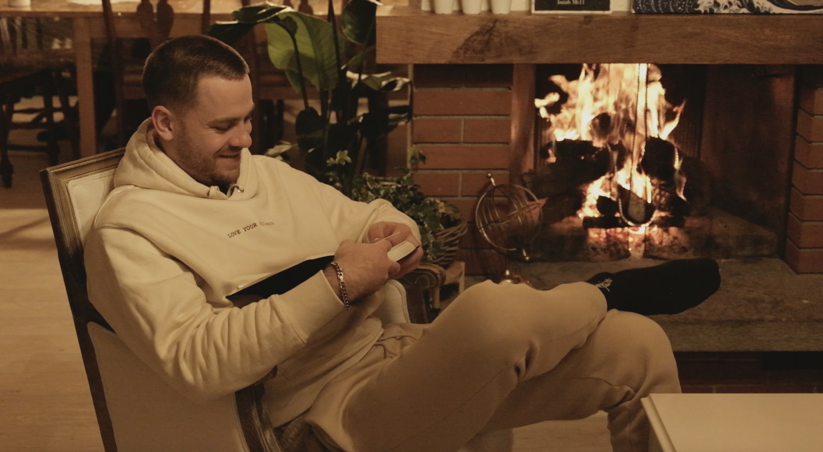 DBS student reading the Bible by a warm fireplace in the evening