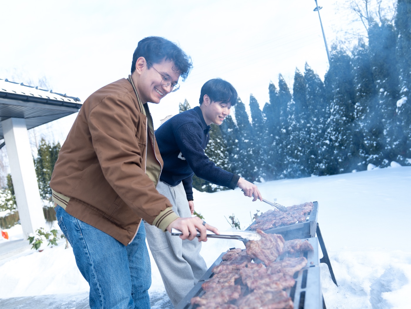 Two students grilling Korean BBQ together in the snow