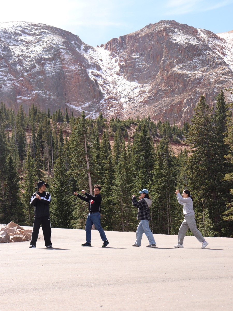 Students walking together below snow-capped Colorado peaks